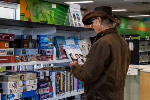 Image of Man browsing jigsaw puzzles and large print books